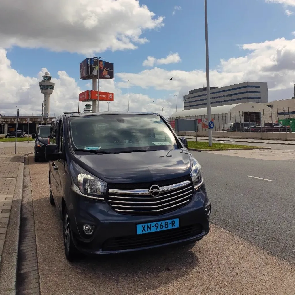 Taxi van Rogis bij de vertrekhal van Schiphol