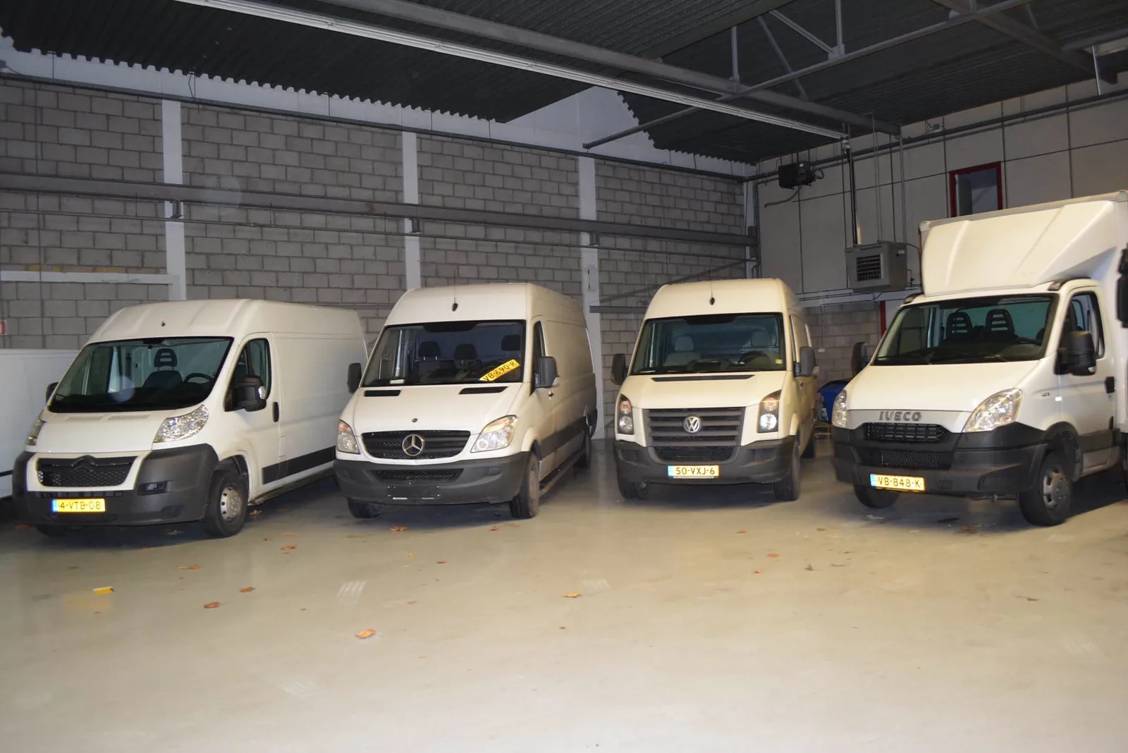Twee koeriersbussen van Rogis Koerier in de loods